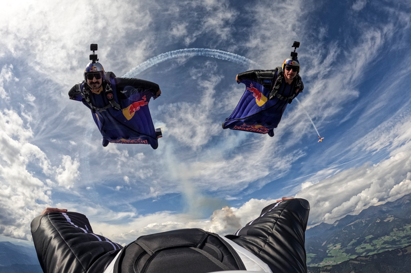 Amura,AmuraWorld,AmuraYachts, El Red Bull Skydive Team durante su participación en la maniobra Aerobática Triple. Al fondo, el Zivko Edge 540 de Dario Costa.