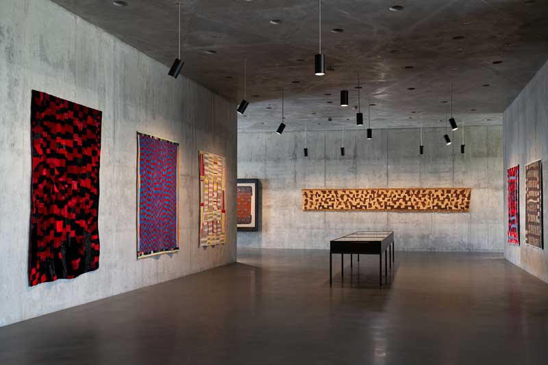 Amura,AmuraWorld,AmuraYachts, Vista de la instalación de la presentación inaugural en las Galerías David Geffen. En la pared de la izquierda se exhiben tres colchas afroamericanas: Rosie Lee Tompkins (1936-2006), <em><i>Hit and Miss Strip</i></em>, 1983; Mary Lue Brown (1891-1979), <em><i>Hit and Miss</i></em>, circa 1945; y Effie Jackson (1899-1989), <em><i>Double Strip</i></em>, principios de la década de 1940. Foto: © Museum Associates/LACMA.