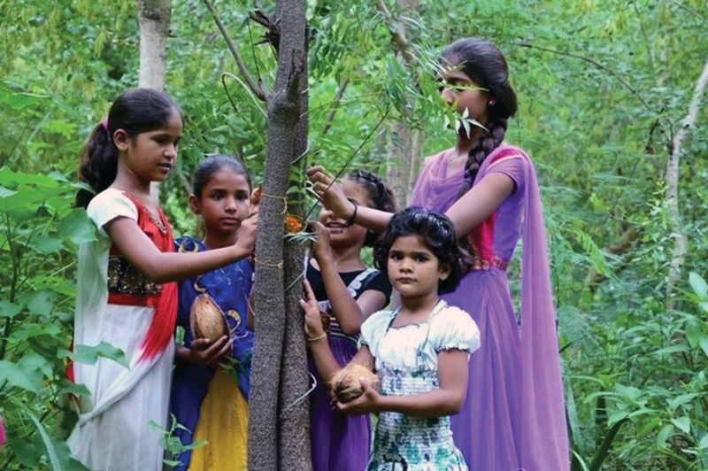 Las niñas y sus familias cuidan de los árboles que se han plantado en su honor. 