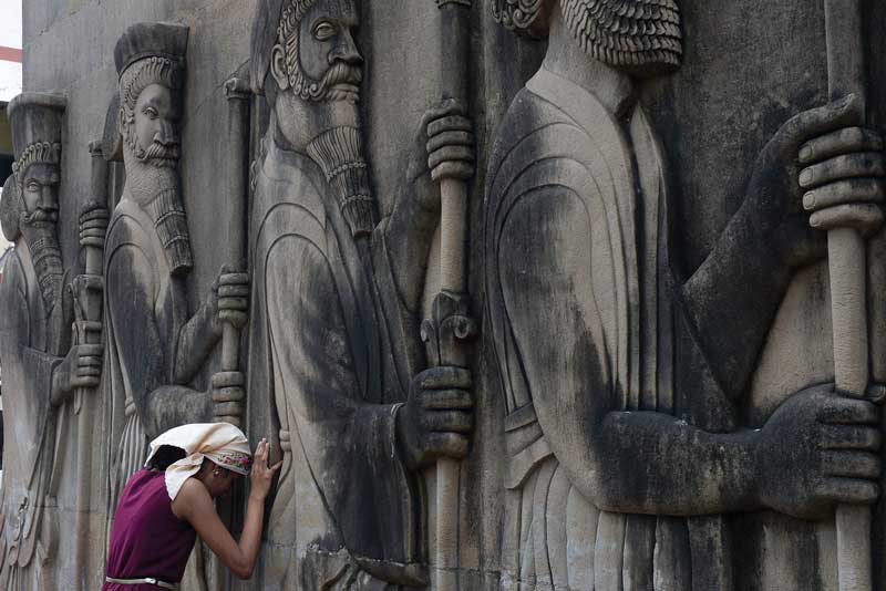 Niña india reza cerca de un  templo de fuego. 