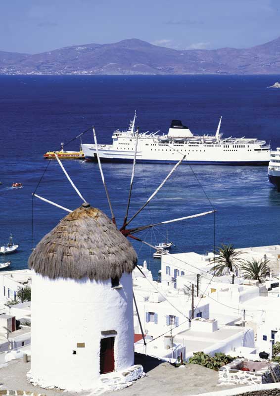 Molino de viento, simbólico de Mykonos, con vista al puerto. 
