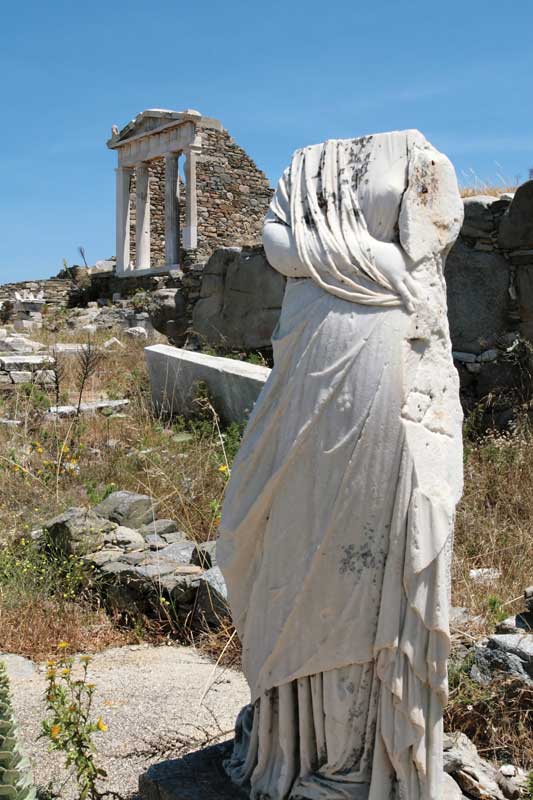 Estatua sin cabeza de una mujer al costado de la Terraza de los dioses extranjeros en Delos.
