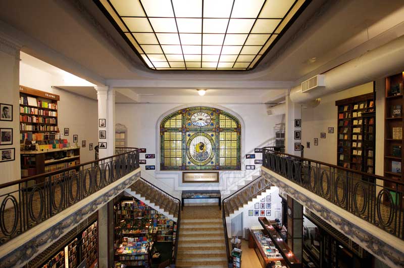 Amura,Librería Puro Verso: simetría, acabados en madera, diferentes tipos de piedras y metales son comunes en la decoración. 